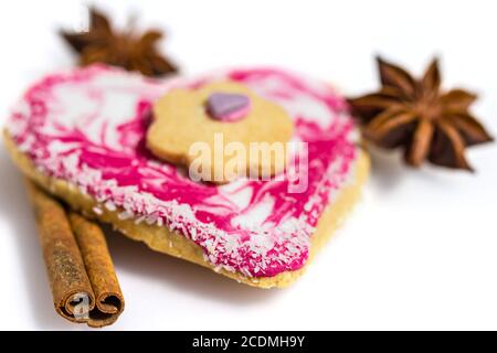 Herzförmige Cookie geschmückt mit Zimt und Sternanis isoliert auf weiss Stockfoto