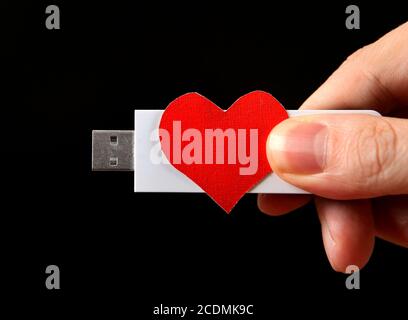 Herzform und USB-Laufwerk in der Hand Stockfoto