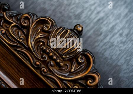 Holzrahmen mit einer Krone auf einer schwarzen Oberfläche geschnitzt Stockfoto