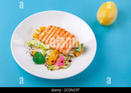 Gegrilltes Lachsfiletsteak mit Salatgarnitur auf weißem Teller Stockfoto