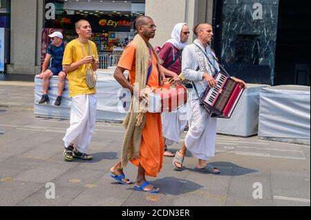 Gruppenhase Krishna singt und spielt Instrumente im Circular Quay An einem bewölkten Sommernachmittag Stockfoto