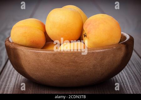 Holzschüssel einige frische Aprikosen auf dem Tisch Stockfoto