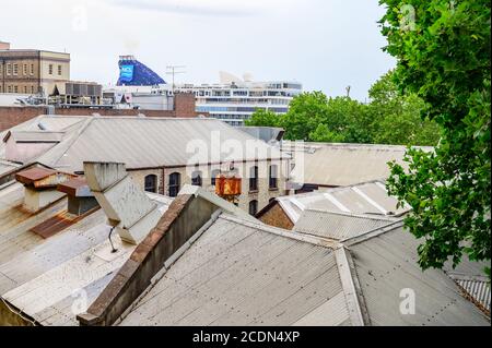 Blick auf die Dächer von The Rocks und eine Kreuzfahrt Schiff am Circular Quay Terminal festgemacht Hintergrund Weichzeichnen auf einem wolkiger Sommernachmittag Stockfoto