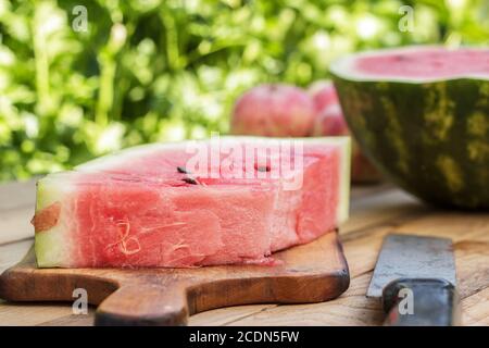 Wassermelone und altes Messer auf dem Tisch Stockfoto