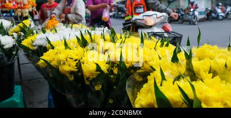 Frische Nelkenblumen werden in einem lokalen Blumengeschäft auf einem Bürgersteig ausgestellt, wunderschöne gelbe und weiße Nelken werden auf einem lokalen Markt in Thailand ausgestellt. Stockfoto