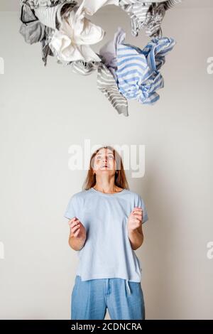 Kaukasische Hausfrau hält Haufen schmutziger Kleidung. Stockfoto