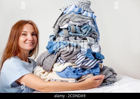 Kaukasische Hausfrau hält Haufen schmutziger Kleidung. Stockfoto