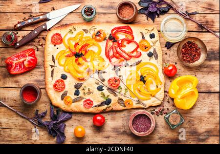 Frisch gebackenes Focaccia-Brot. Italienische Focaccia mit Paprika, Tomaten und Basilikum Stockfoto