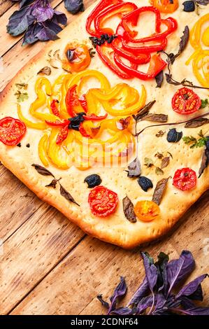 Hausgemachte italienische Focaccia mit Paprika, Tomaten, Basilikum und Oliven. Stockfoto