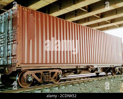 Container auf Eisenbahnwaggons auf einer Eisenbahn beladen Stockfoto