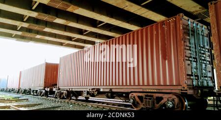 Container auf Eisenbahnwaggons auf einer Eisenbahn beladen Stockfoto