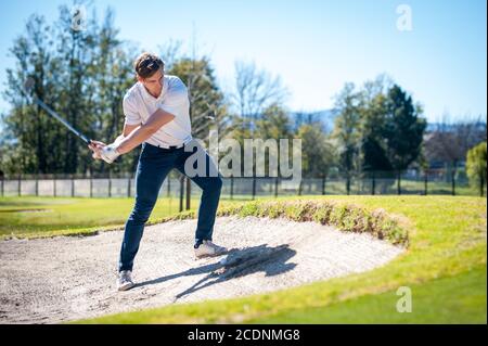 Bild eines Golfspielers, der einen Chip-Schuss auf den spielt Grün auf einem Golfplatz in Südafrika Stockfoto