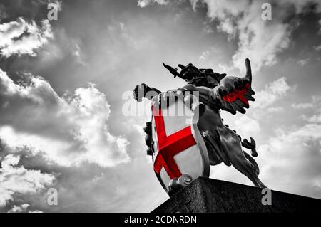 St George Drachenstatue in London, Großbritannien. Schwarz und weiß, rote Fahne, Schild. Stockfoto