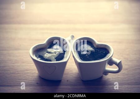 Schwarzer Kaffee, Espresso in zwei herzförmigen Tassen. Liebe, Valentine#39;s Tag, vintage Stockfoto