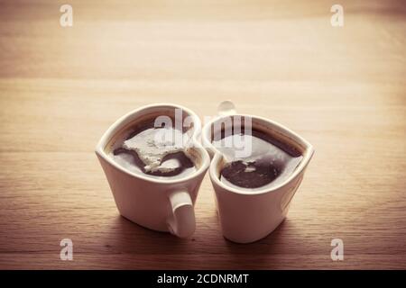 Schwarzer Kaffee, Espresso in zwei herzförmigen Tassen. Liebe, Valentine#39;s Tag, vintage Stockfoto