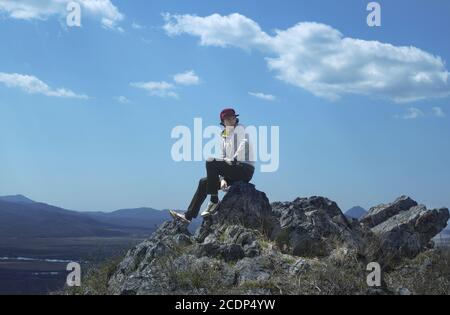 Junger sportlicher Mann in roter Mütze sitzen Stockfoto