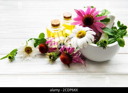 Medizinische Blumen und Pflanzen in Mörtel und ätherische Öle auf Ein weißer Holztisch Stockfoto