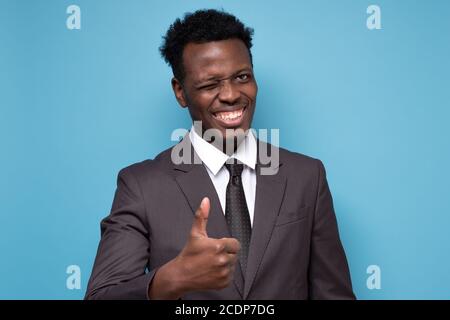Happy african junge Geschäftsmann zeigt Daumen nach oben Genehmigung Ihrer Wahl. Stockfoto