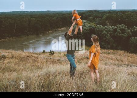 Familie Vater und Mutter mit Kind spielen im Freien Eltern mit Baby mit Spaß aktiv gesund Lebensstil glücklich Emotionen Fluss und Waldlandschaft Stockfoto