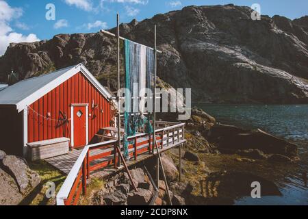 Rotes Holzhaus Fischerdorf in Norwegen traditionelle Architektur Rorbu Und Fjord mit felsigen Bergen skandinavische Reiseziele Landschaft Stockfoto