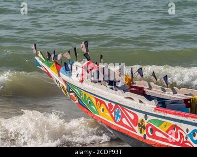 Nianing, Senegal - 24. Januar 2019: Buntes Fischerboot aus Holz, das am Sandstrand im Senegal steht. Afrika Stockfoto