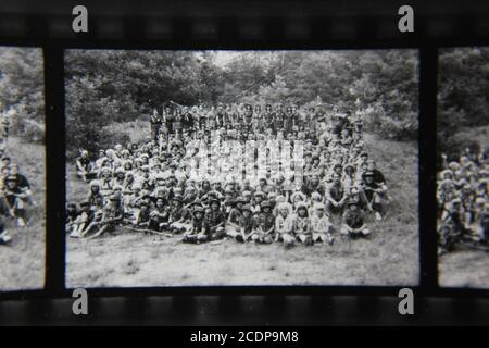 Feine Schwarz-Weiß-Fotografie aus den 1970er Jahren von einer Gruppe von Hunderten von Pfadfindern, die in einem Sommerscout-Camp in der freien Natur campen. Stockfoto