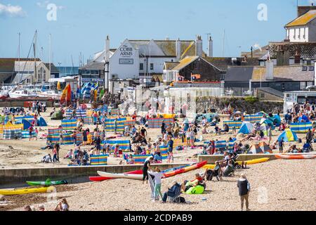 Lyme Regis, Dorset, Großbritannien. August 2020. UK Wetter: Urlauber und Familien strömen an den Strand am Badeort Lyme Regis, um den letzten Sommerurlaub an einem stürmischen Tag mit heißen Sonnenzaubern zu genießen. Kredit: Celia McMahon/Alamy Live Nachrichten Stockfoto