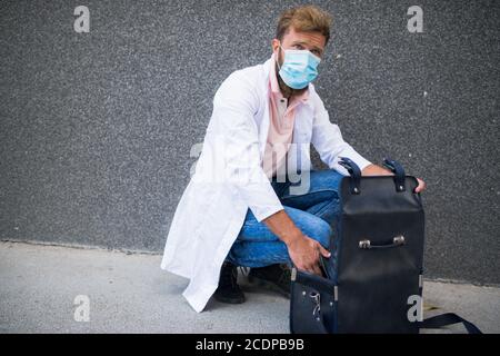 Junger Arzt, der eine Arzttasche trägt Stockfoto