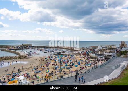 Lyme Regis, Dorset, Großbritannien. August 2020. UK Wetter: Urlauber und Familien strömen an den Strand am Badeort Lyme Regis, um den letzten Sommerurlaub an einem stürmischen Tag mit heißen Sonnenzaubern zu genießen. Kredit: Celia McMahon/Alamy Live Nachrichten Stockfoto