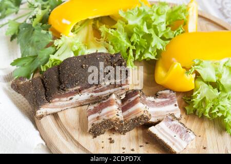 Eine köstliche geräucherte Rippchen mit Gewürzen um frischen gelben Pfeffer Salatblätter Petersilie Stockfoto