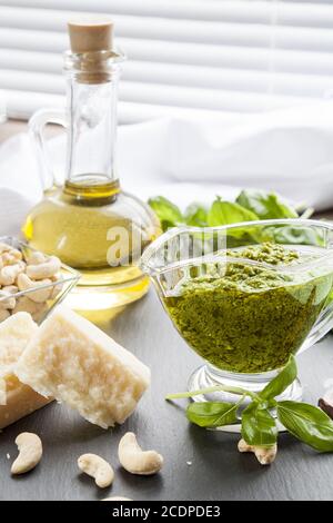 Basilikum Basilikumblätter Pesto frische Parmigiano-Käse-Oliven-Öl und Cashew-Kerne auf schwarzem Stein Stockfoto