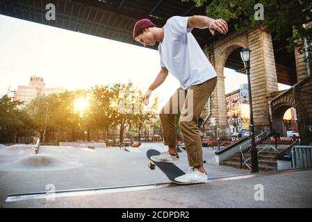 Kleiner Junge macht Tricks mit dem Skateboard im Skate parken Stockfoto