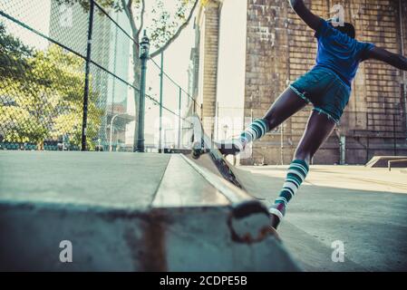 Junges Mädchen, das Tricks mit dem Skateboard in einem Skate parken Stockfoto