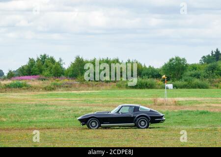 Schwarze Chevrolet Corvette Stingray Fahren in einer Landschaft Stockfoto