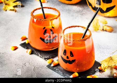 Halloween orange Festgetränk und Kürbis Wachen auf grauen Herbst Hintergrund mit süßen Mais, gefallenen Blättern und Feuer Lichter, selektive Fokus Stockfoto