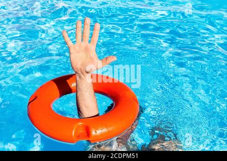 Arm durch orange Boje im Schwimmbad Stockfoto