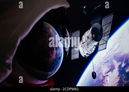 Astronaut schaut aus dem Fenster seiner Kapsel in den Weltraum, die Galaxie und die Planeten. Konzept über Wissenschaft und Weltraumforschung Stockfoto