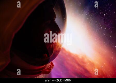 Astronaut schaut aus dem Fenster seiner Kapsel in den Weltraum, die Galaxie und die Planeten. Konzept über Wissenschaft und Weltraumforschung Stockfoto