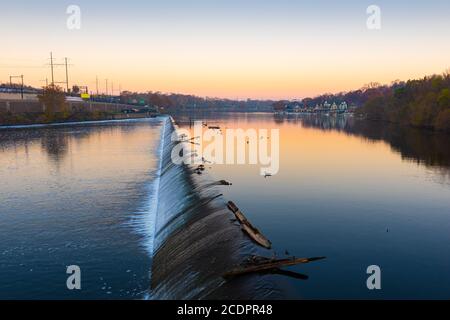 Philadelphia, Pennsylvania, USA Damm auf dem Schuylkill River mit Boathouse Row in der Ferne bei Sonnenaufgang. Stockfoto