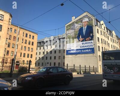 Riga, Lettland. August 2020. An einer Hauswand in der lettischen Hauptstadt Riga hängt ein Wahlplakat der Partei "Gods kalpot Rigai" (Es ist eine Ehre, Riga zu dienen) mit einem Porträt des ehemaligen Bürgermeisters Olegs Burovs. Die Bürger der lettischen Hauptstadt wählten am Samstag (29. August) einen neuen Bürgermeister und einen stadtrat. Quelle: Alexander Welscher/dpa/Alamy Live News Stockfoto