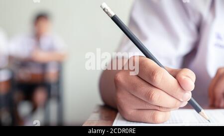 Hand der Schüler schriftlich und Prüfung mit Stress in Klassenzimmer.16:9 Stil Stockfoto