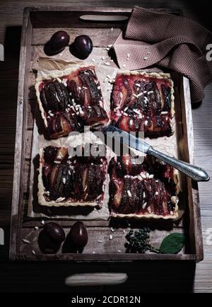 Eine quadratische Galette schön auf einem hölzernen Tablett auf einem Tisch angeordnet, flach legen Stockfoto