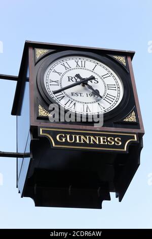 Odense, Dänemark - 16. August 2018: Stadtuhr mit Guinness Bierschild. Guinness ist ein dunkler irischer Trockenstout Stockfoto