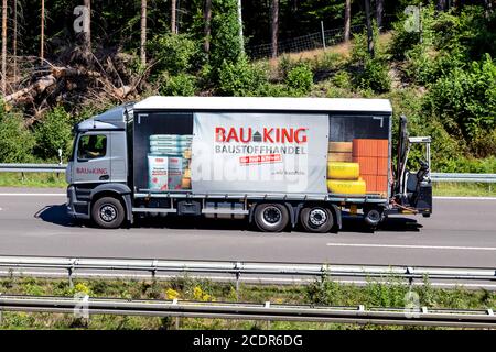 BAUKING LKW auf der Autobahn. BAUKING ist einer der Marktführer im deutschen Baustoff- und Holzhandel. Stockfoto