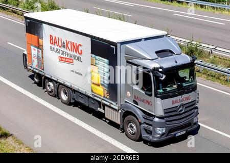 BAUKING LKW auf der Autobahn. BAUKING ist einer der Marktführer im deutschen Baustoff- und Holzhandel. Stockfoto