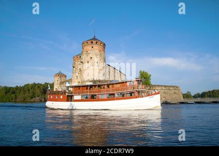 SAVONLINNA, FINNLAND - 24. JULI 2018: An einem sonnigen Sommertag fährt ein Lustschiff an der alten Festung Olavinlinna vorbei Stockfoto