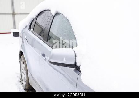 Einschlafen nassen Schnee Auto. Schneefall von nassem Schnee. Schnee liegt auf dem Auto Stockfoto