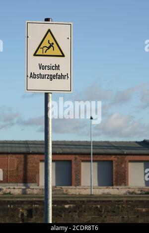 Schild mit der Aufschrift Fallgefahr im Hafen Magdeburg Stockfoto