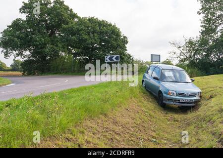Verlassene Auto in einem Graben, nachdem es eine Ecke zu schnell dauerte. Stockfoto