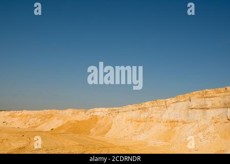 Klippe der gelb orange braun Sand Boden Ton unter den sonnigen Tag mit tiefblauen Himmel Stockfoto